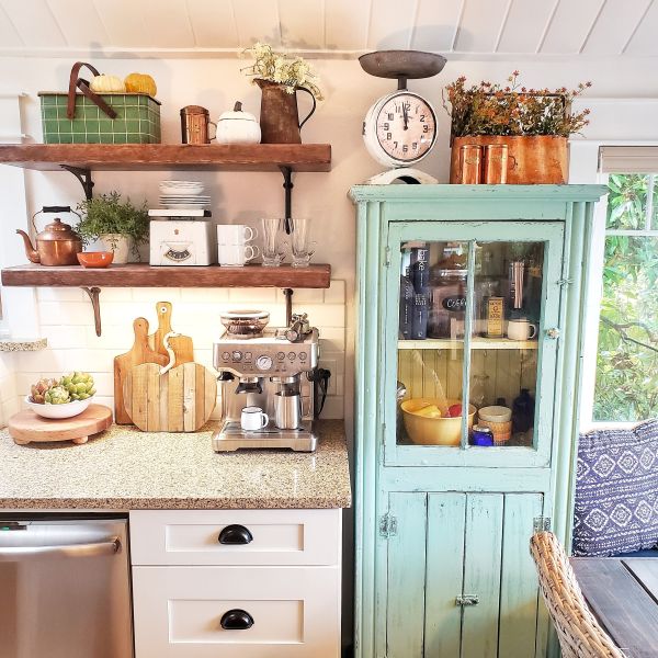 Turquoise glass cabinet and open shelving in cottage kitchen