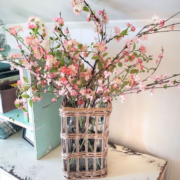 faux cherry blossoms in a rattan vase holder