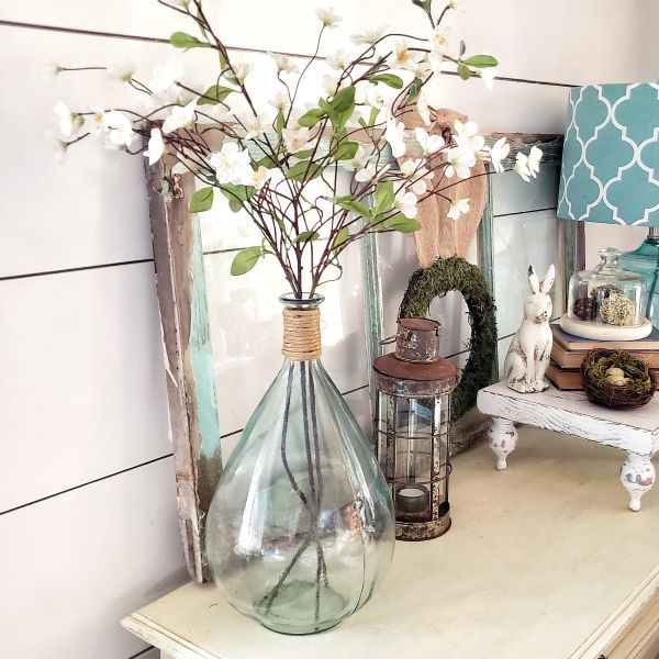 faux dogwood branches in glass vase and spring decor