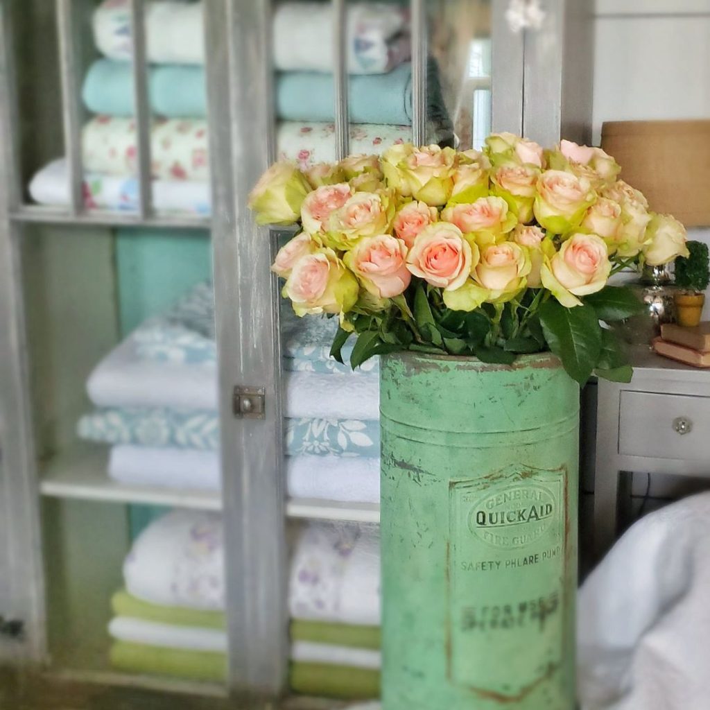 Fresh pink roses in a vintage green phlare pump.