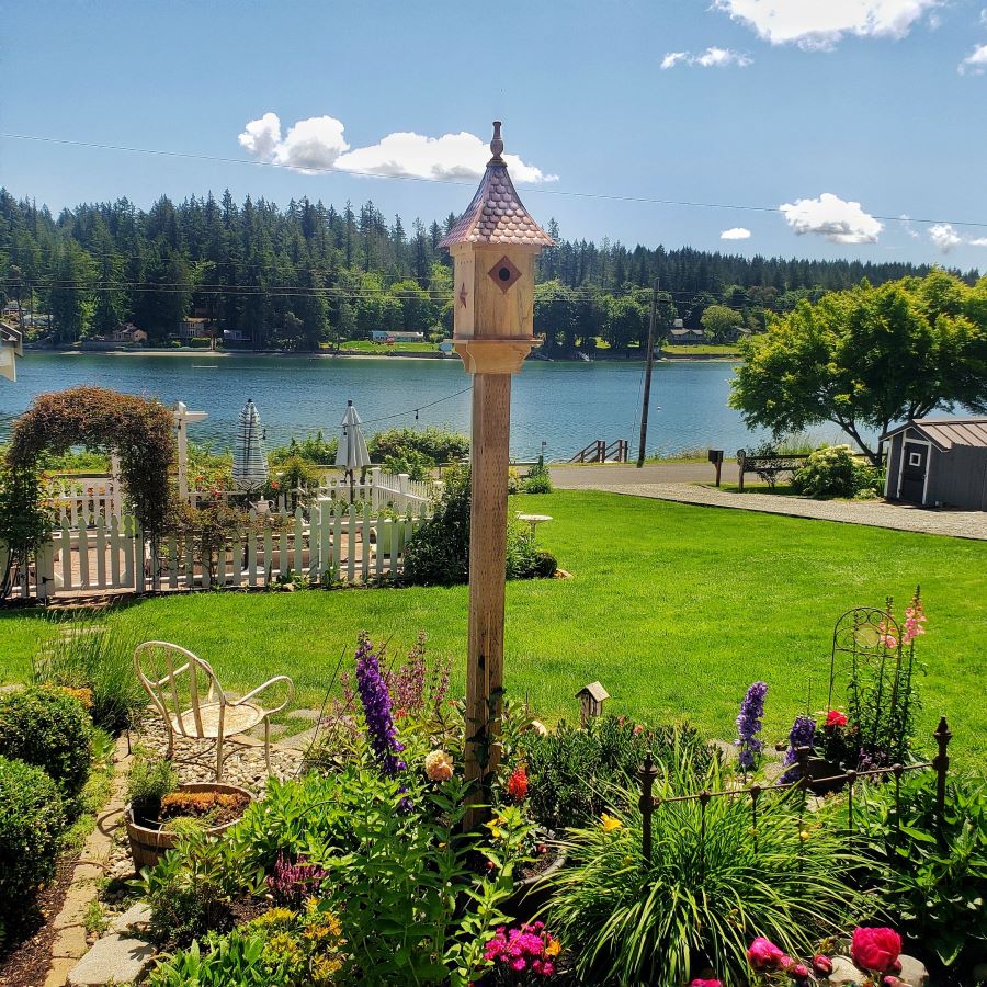 birdhouse and a white picket fence garden