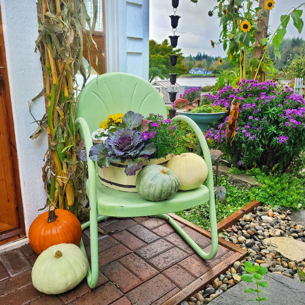 green vintage metal chair with fall flowers and pumpkins