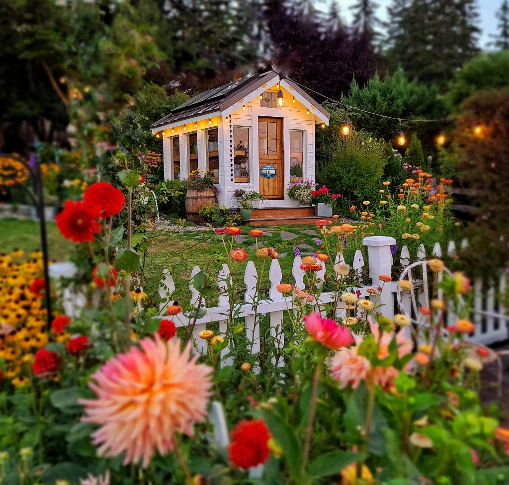 greenhouse with white picket fence and flowers