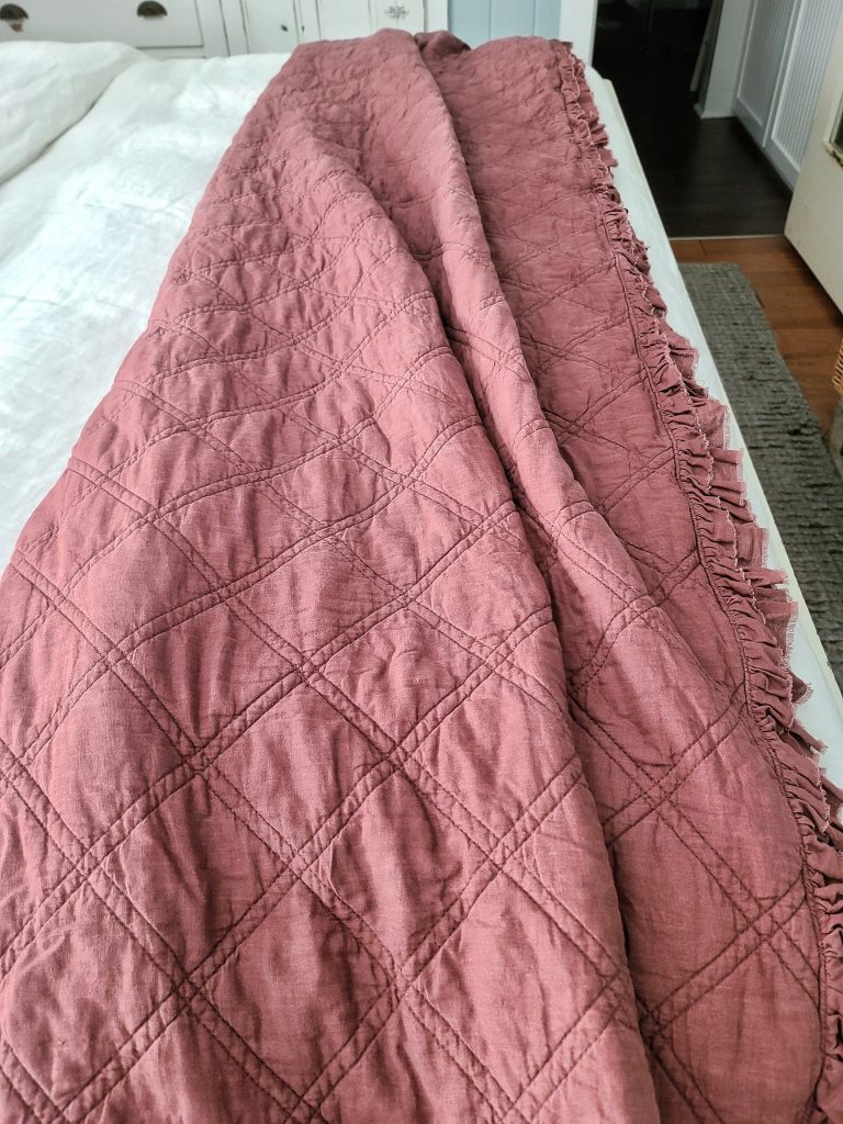 rose colored quilt on bed