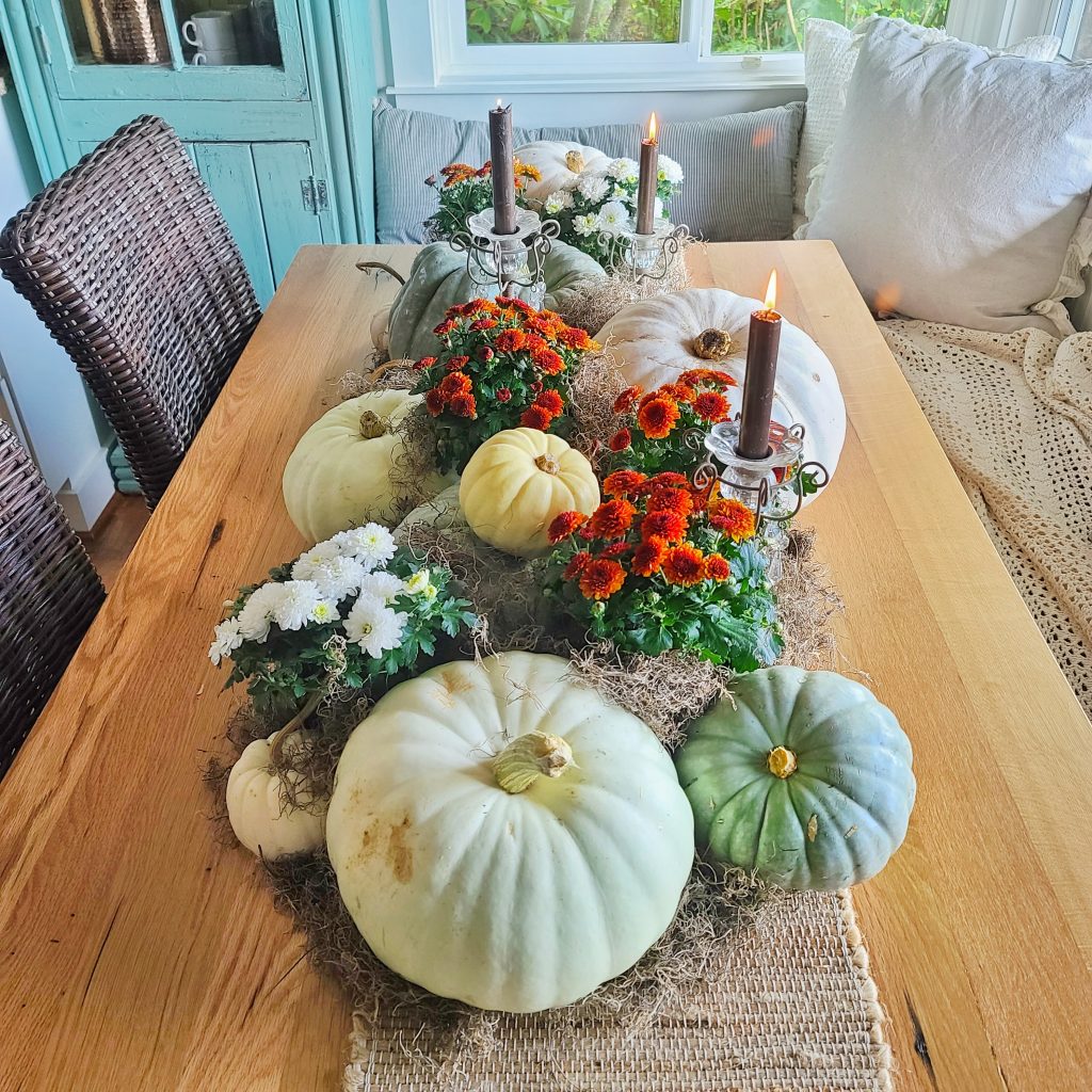 kitchen table with pumpkins and mums with candles