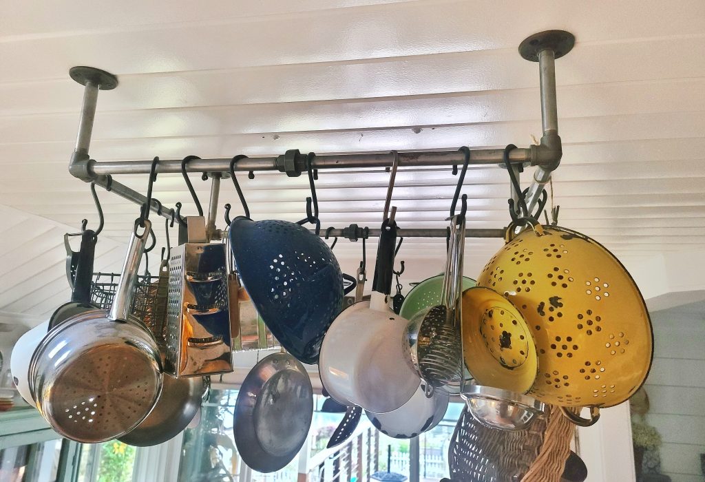pot rack with pots and pans hanging off of it