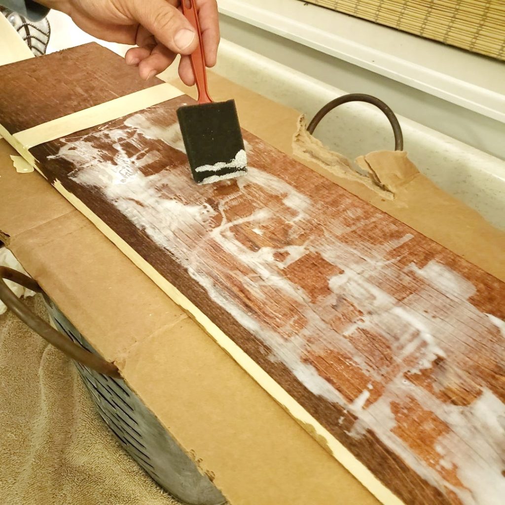brushing glue on a stained board