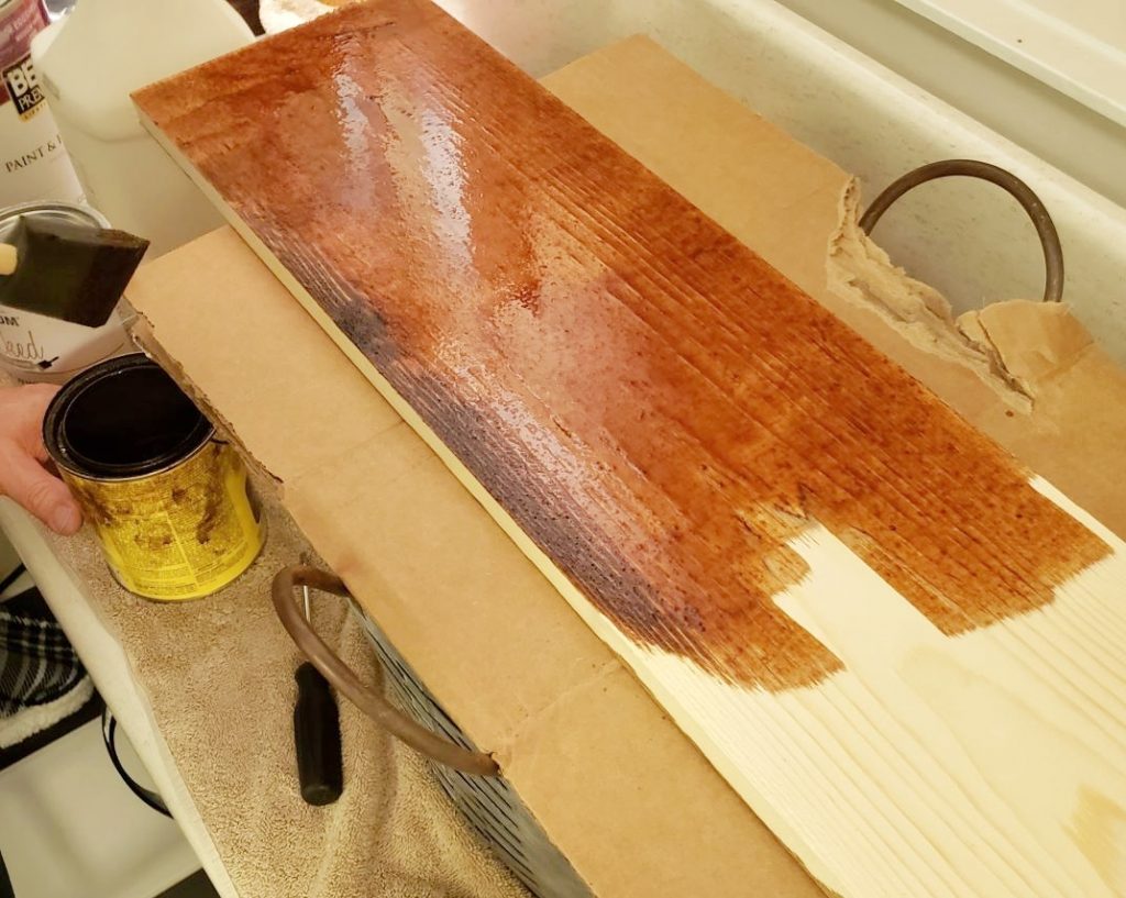 adding stain to a wood board