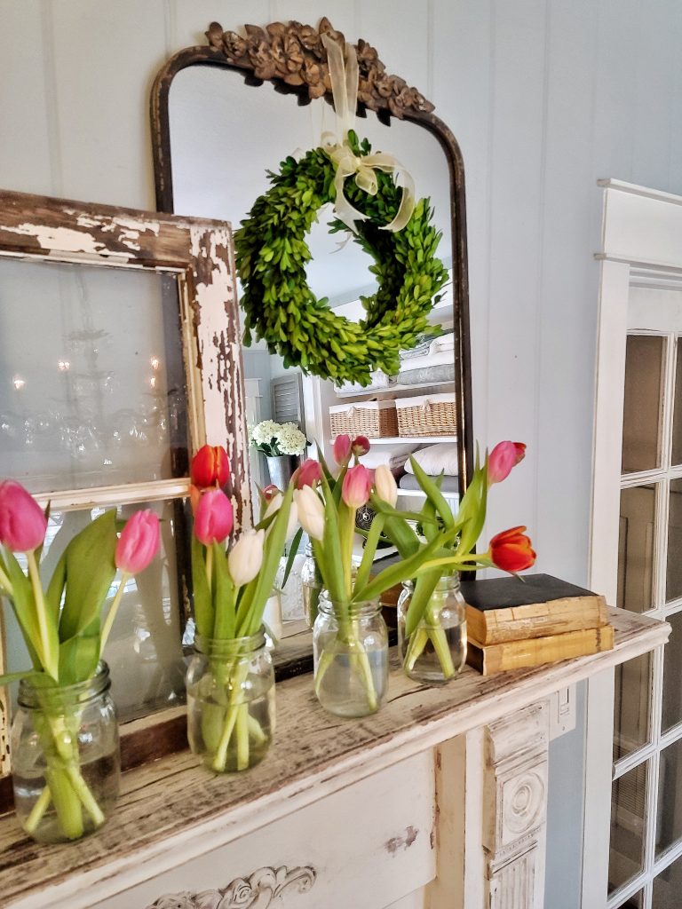 tulips in glass jars on mantel