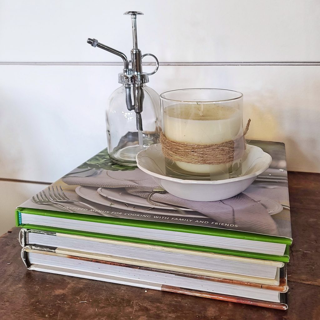 glass plant mister candle and books