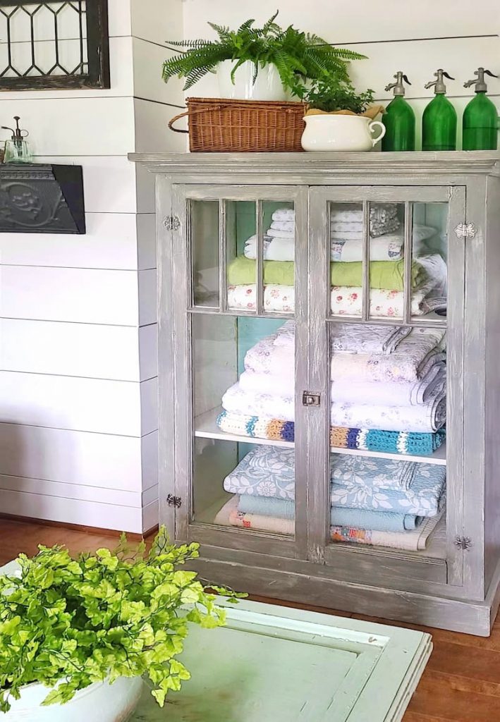 vintage glass cabinet with quilts and blankets