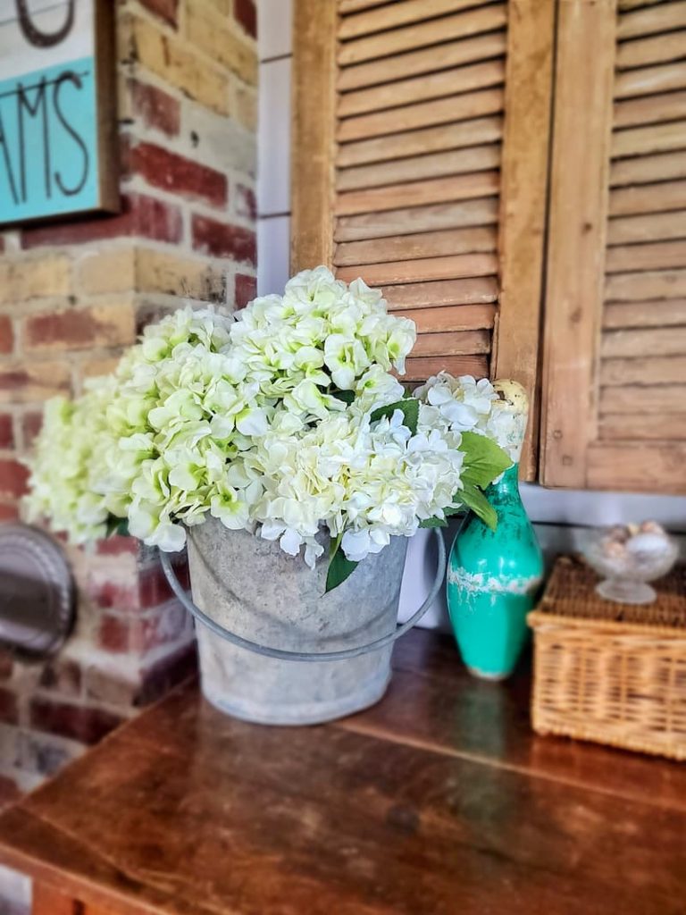 faux hydrangea flowers in a vintage galvanized bucket