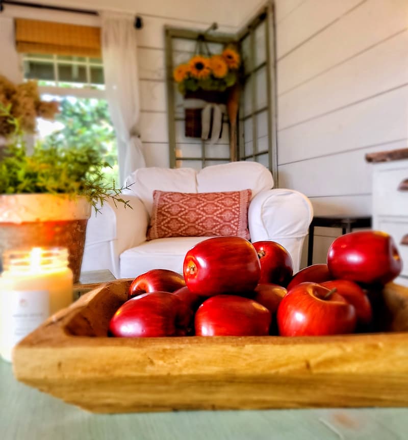 red faux apples in a rustic dough bowl