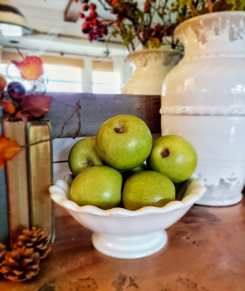 green apples in white ironstone pedestal bowl