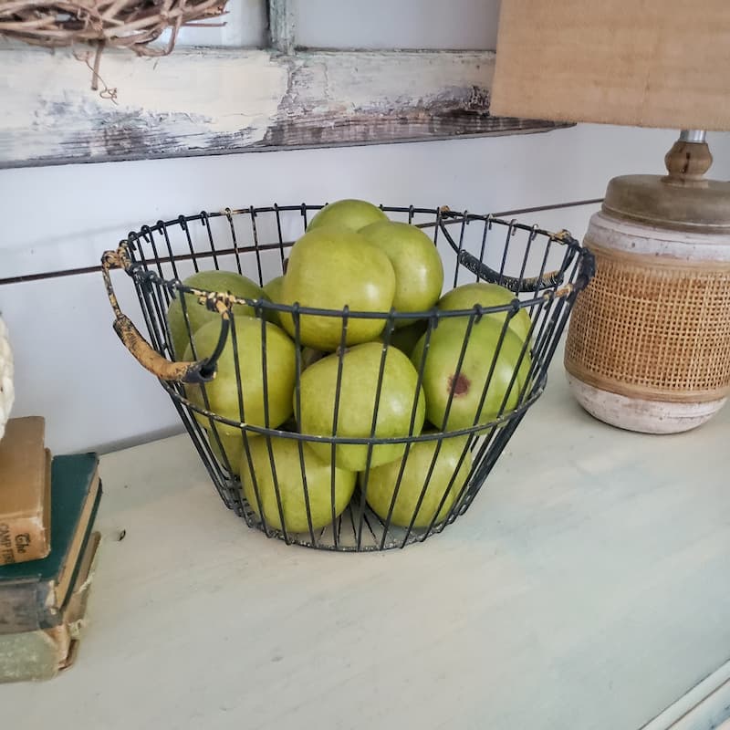 wire basket with green apples