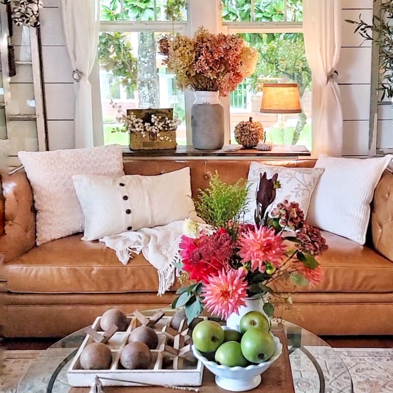 fresh flowers, green apples in white bowl and game board on coffee table