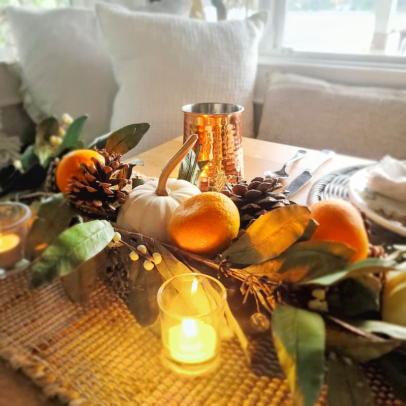 clementines and white pumpkins with candlelight