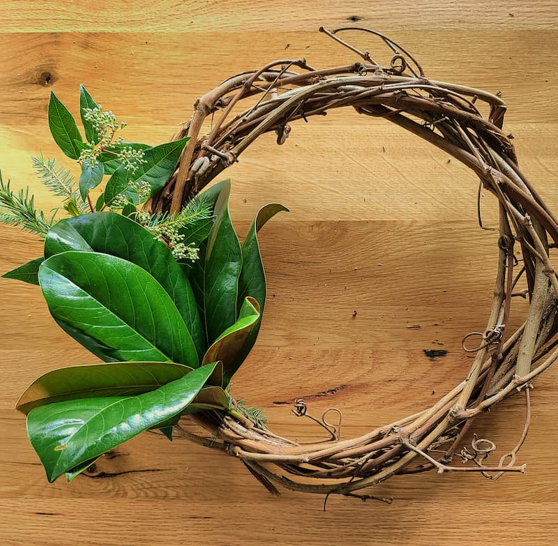 magnolia leaves being tied to wreath