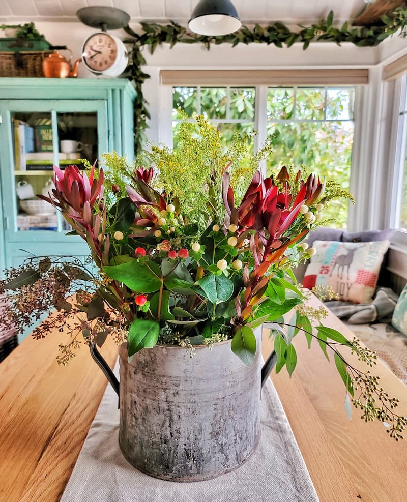 Christmas flowers and greenery in a galvanized bucket