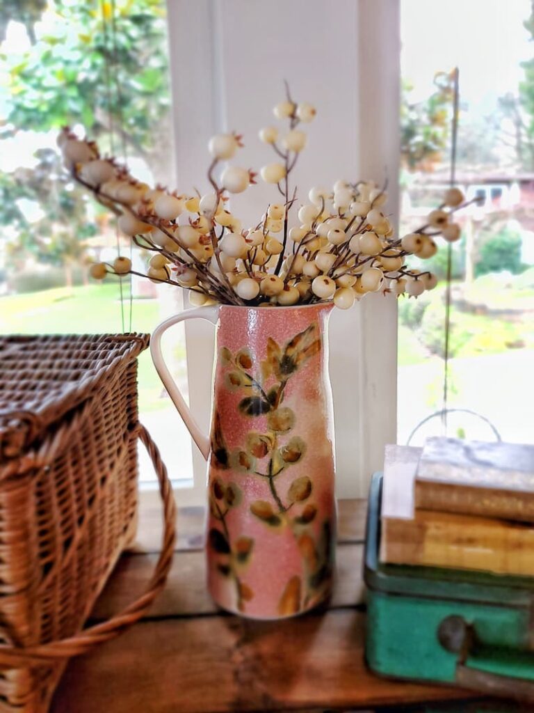 rose colored pitcher with olive print and white berries
