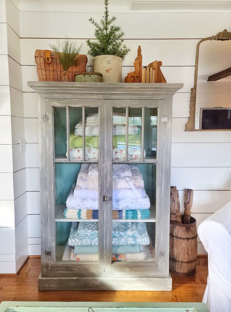 glass armoire with quilts and linens