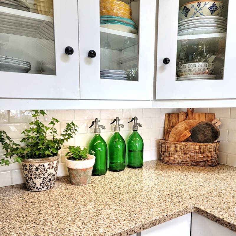 vintage green seltzer bottles and greenery on counter