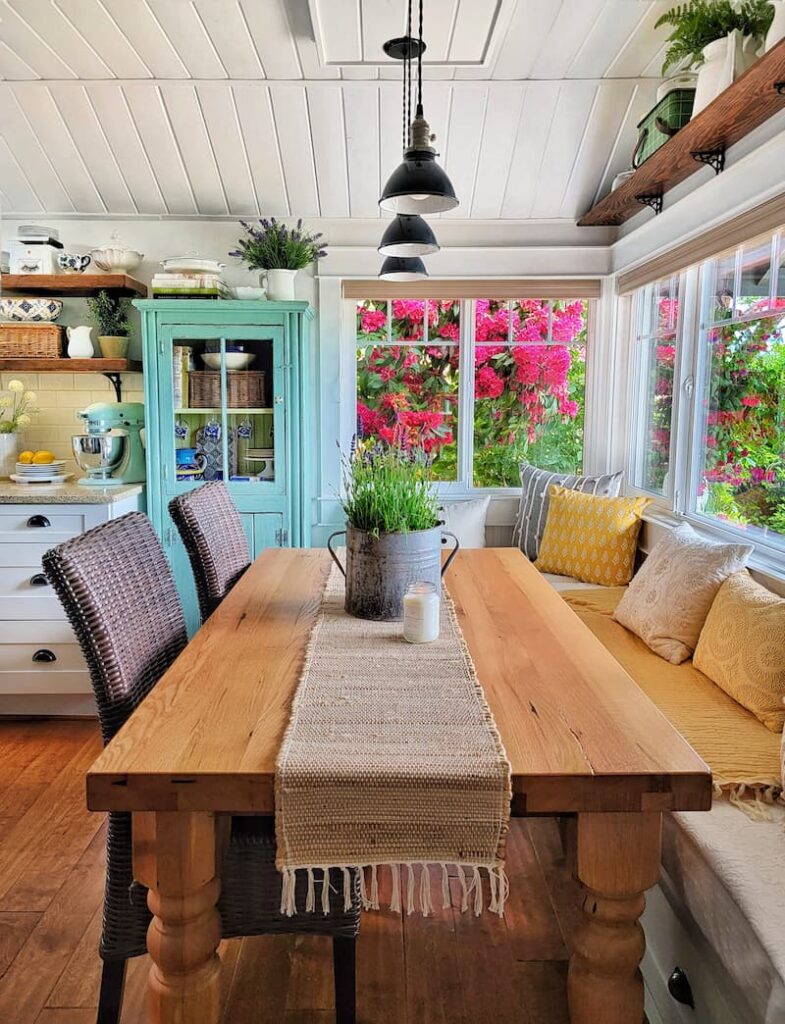cottagecore kitchen decor: kitchen eating area with view of fuchsia flowers through the window