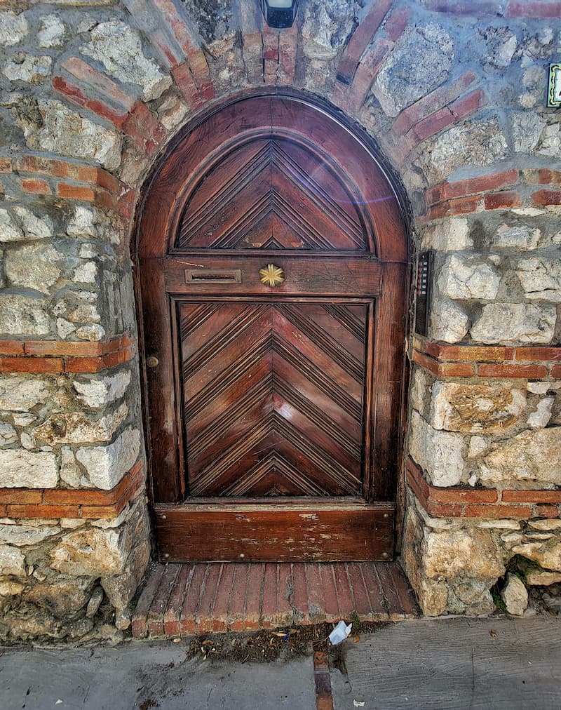 wooden curved door with stone and brick columns