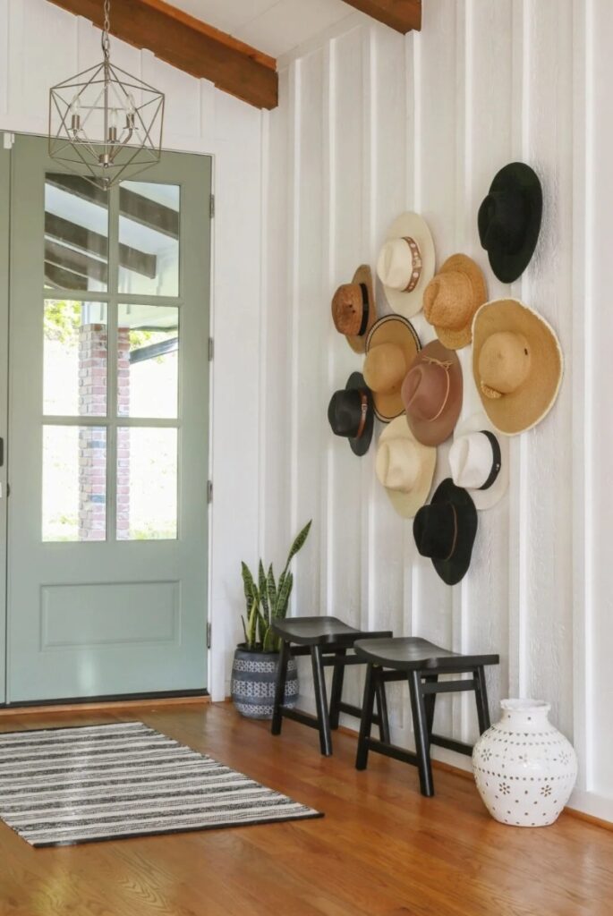 entryway with green French door and hats