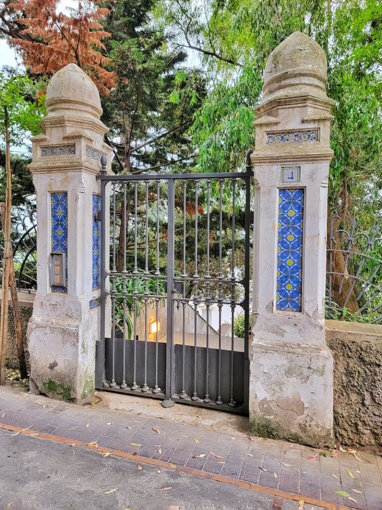 black iron gate with cement columns and tile details