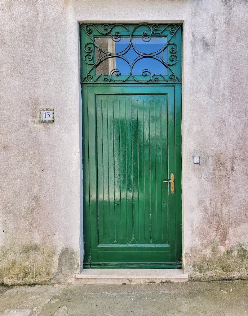green rectangle wooden door and iron transom window