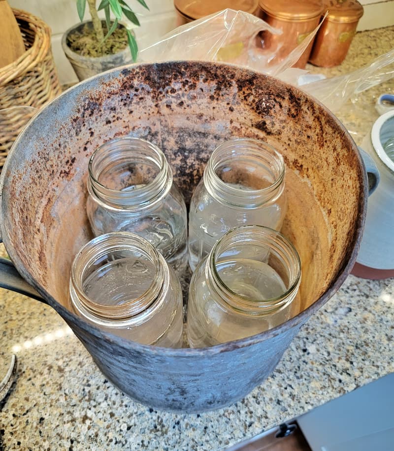 glass mason jars filled with water in a vintage galvanized bucket