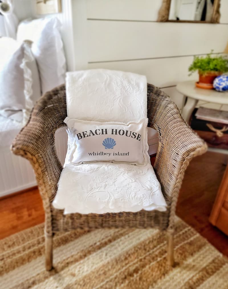 beach house pillow and wicker chair