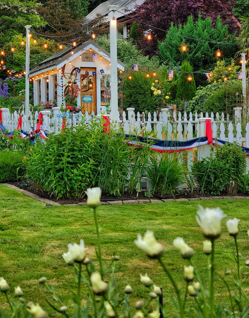 greenhouse and white picket fence garden with patriotic décor
