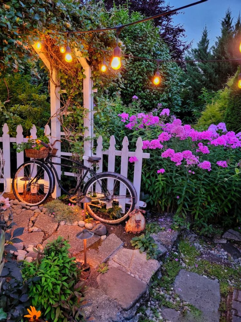 summer garden pathway with vintage bike and white picket fence
