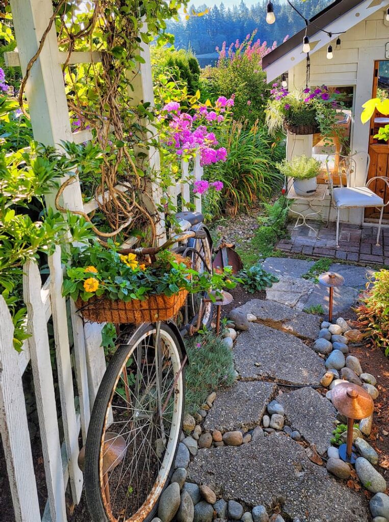vintage bike and basket filled with flowers on garden path