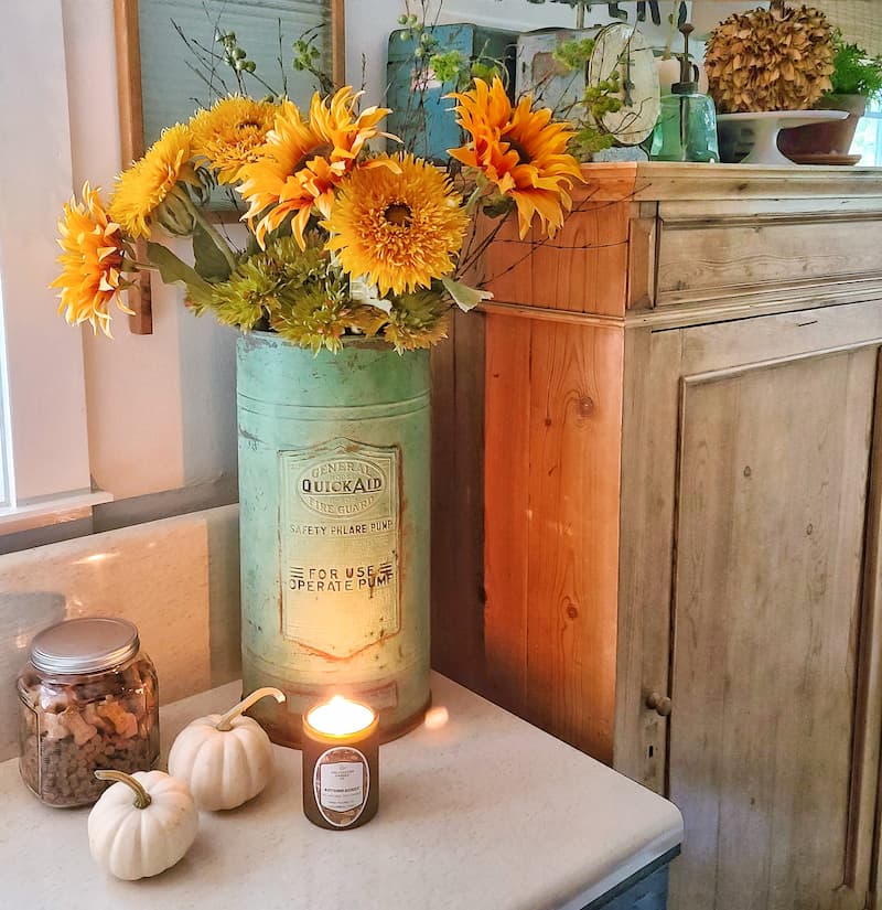 faux sunflowers in a vintage green container