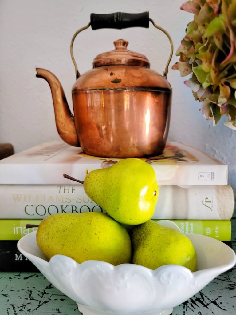 copper teakettle and pears in a vintage ironstone bowl