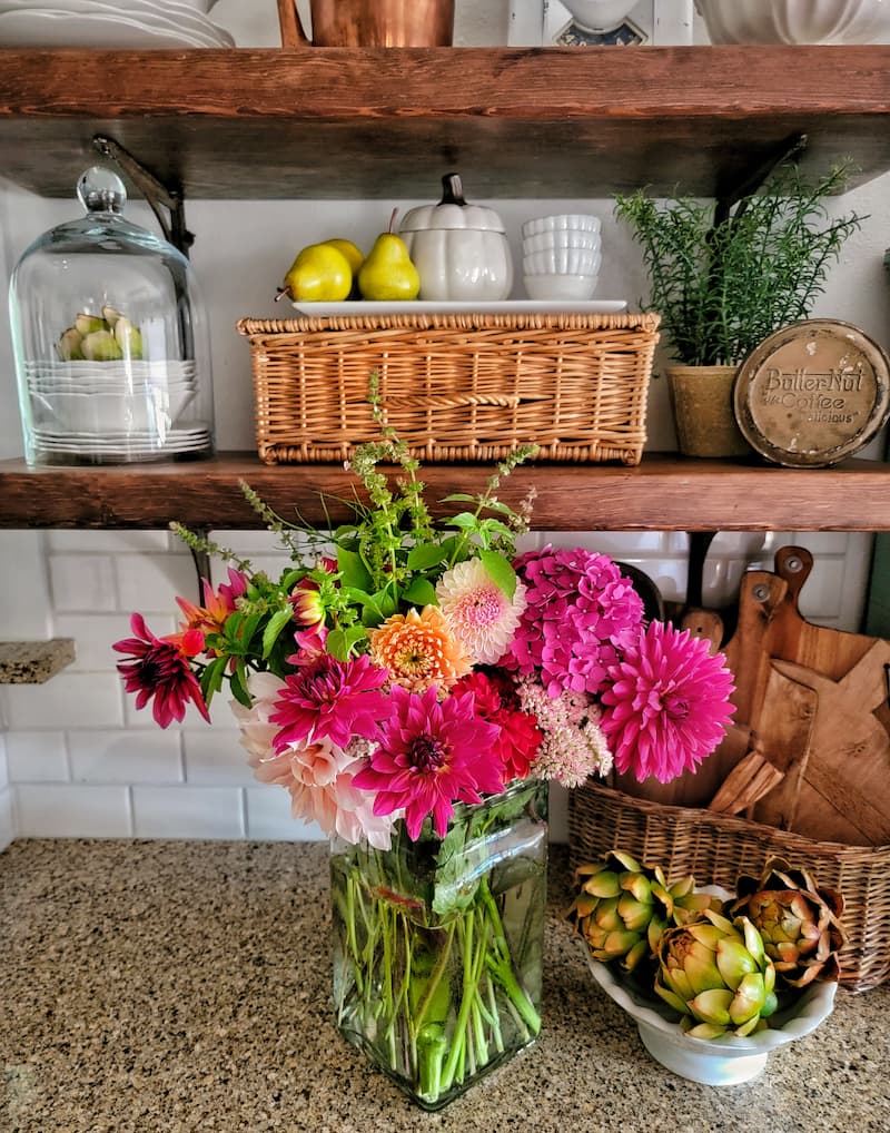open shelves with vintage wicker baskets and fresh flowers