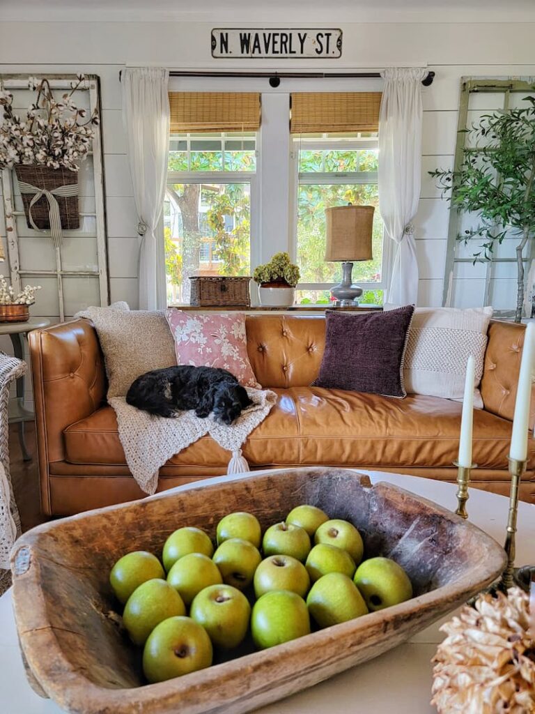 wooden dough bowl with green apples on the coffee table for fall
