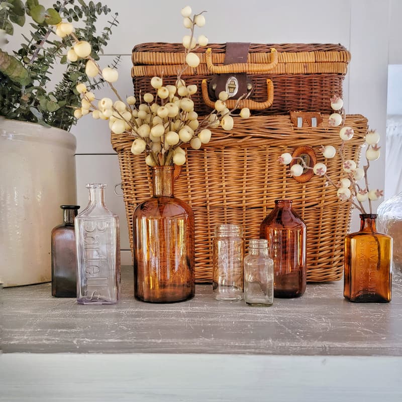 vintage picnic basket with clear and amber glass bottles