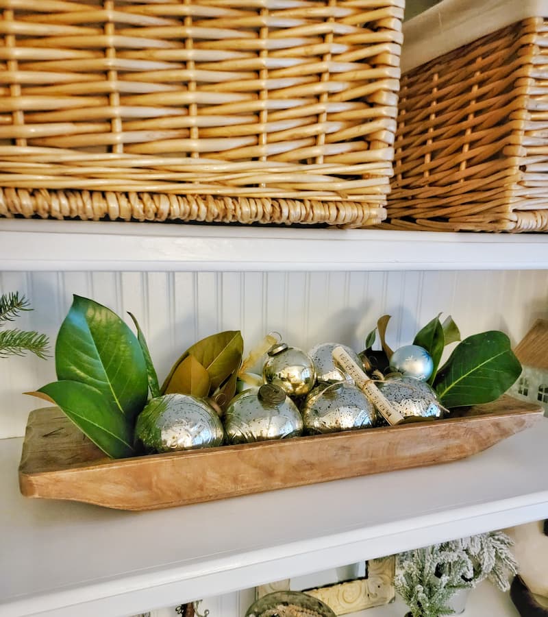 Cottage Christmas decor ideas: wooden dough bowl with magnolia leaves and mercury glass ornaments