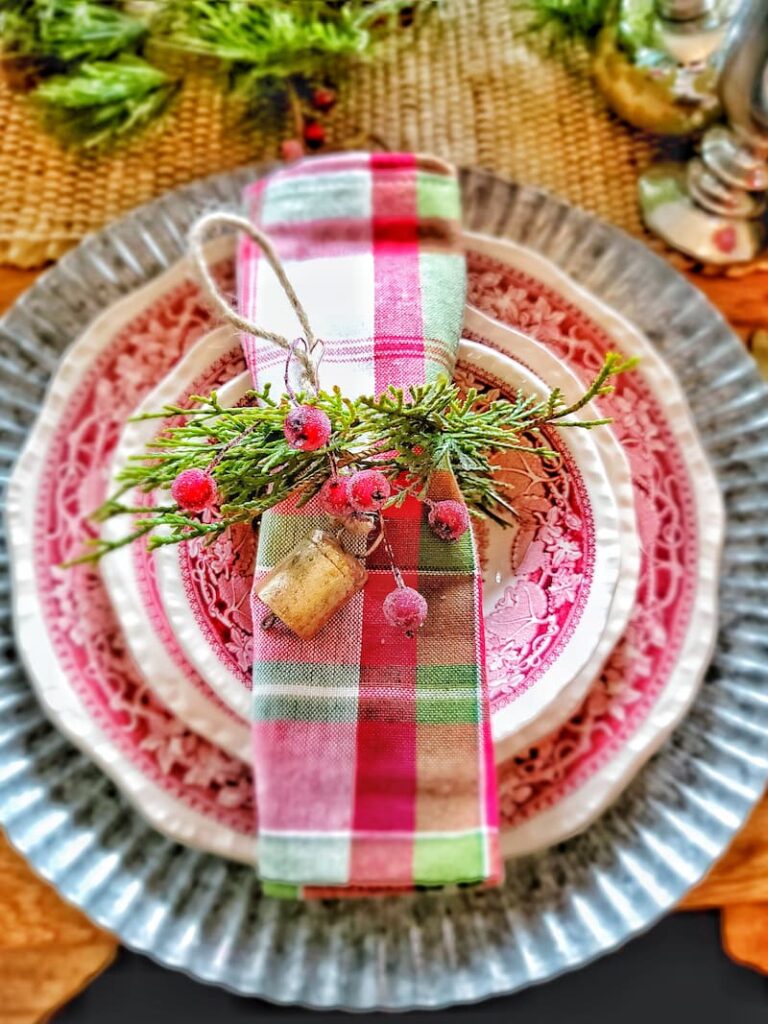 Christmas natural elements:  red and white dishes with plaid napkin and ring with greenery and berries
