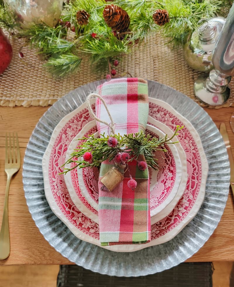 Cottage Christmas decor ideas: Christmas table setting with plaid napkin and greenery