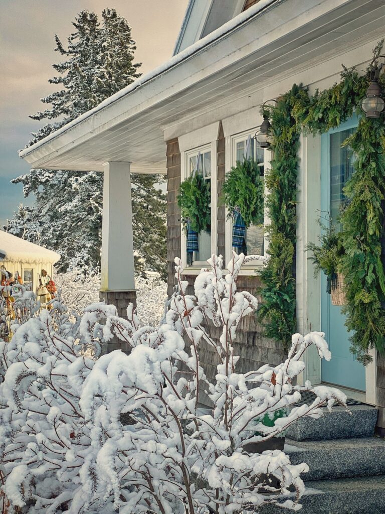 front porch with snow falling