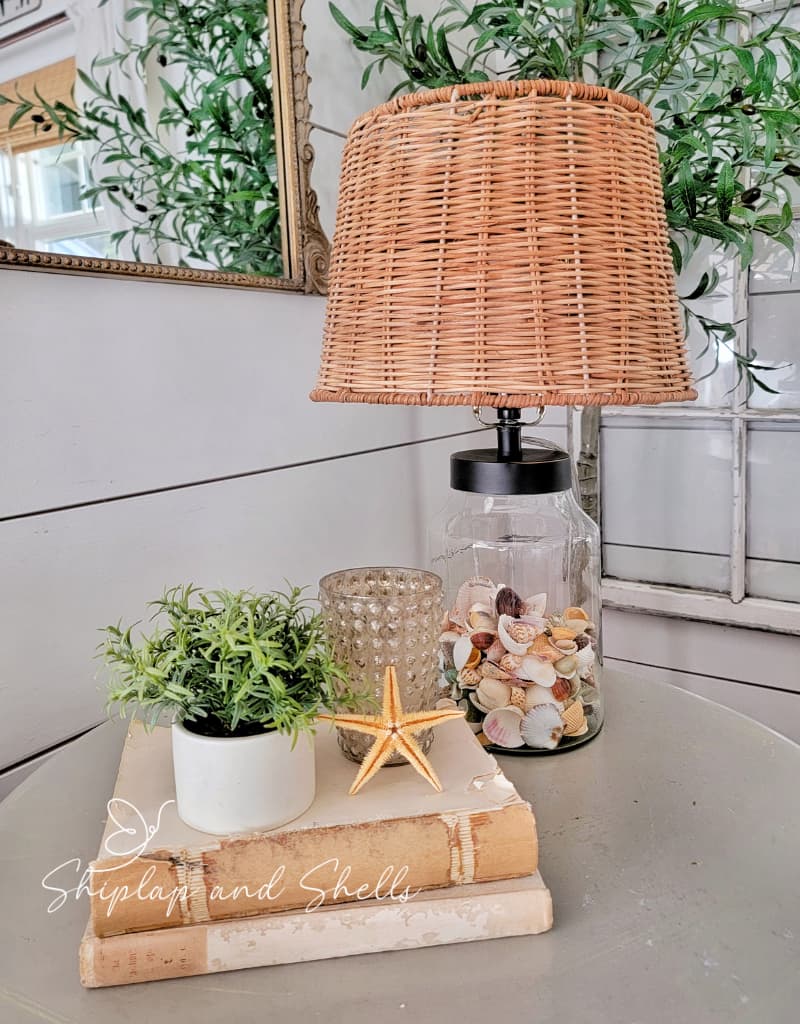 wicker lampshade with seashell base and vintage books