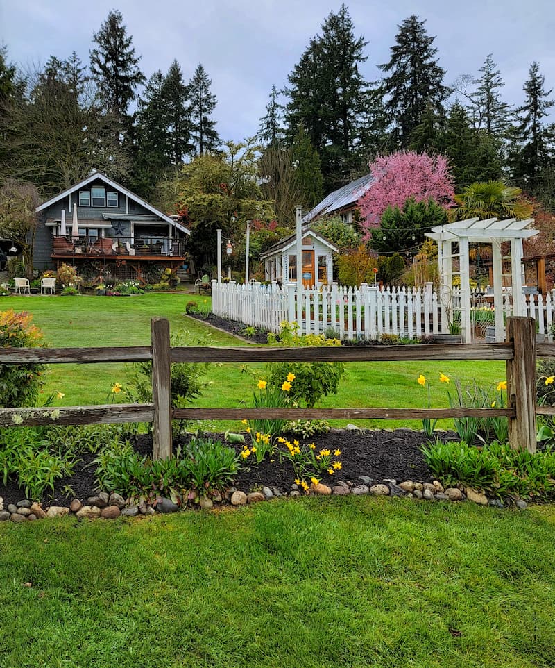 cottage and greenhouse with white picket fence garden and split rail fence