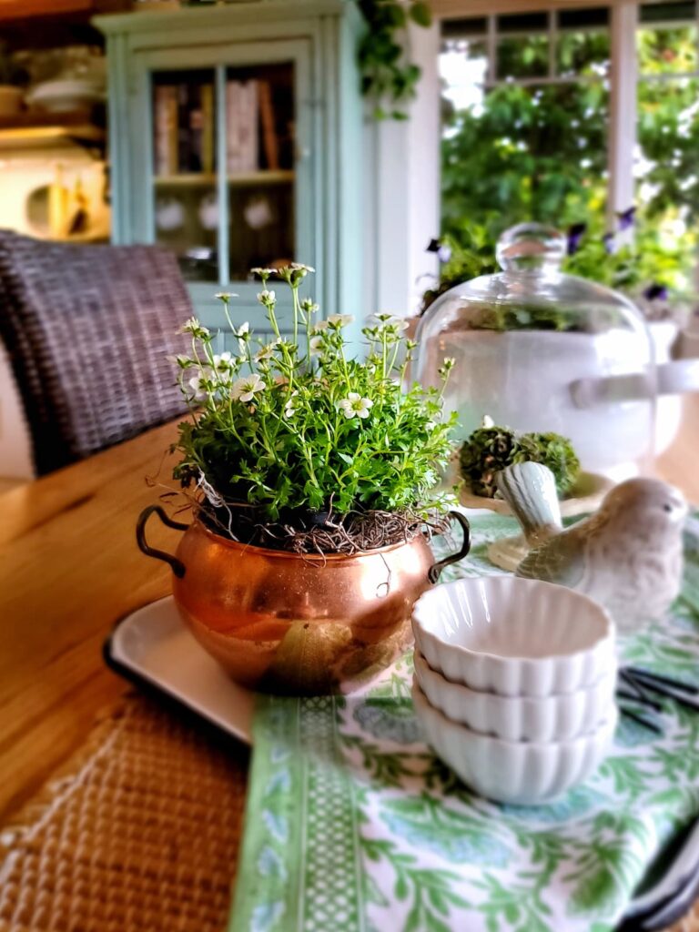 spring flowers in vintage copper pot and white ceramic bird centerpiece