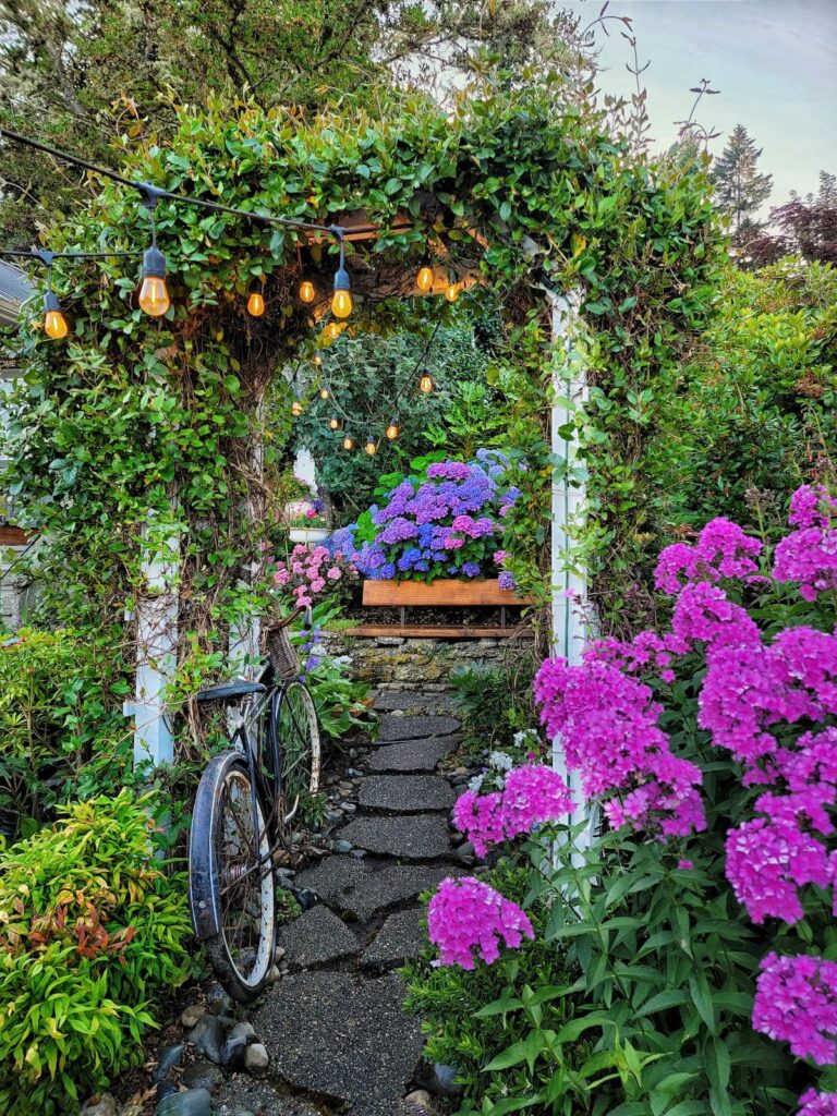 garden pathway with plants growing on an arbor