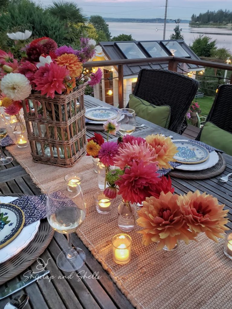 Summer tablescape ideas:  outdoor summer table with vases of dahlias  and tealight candles as centerpiece